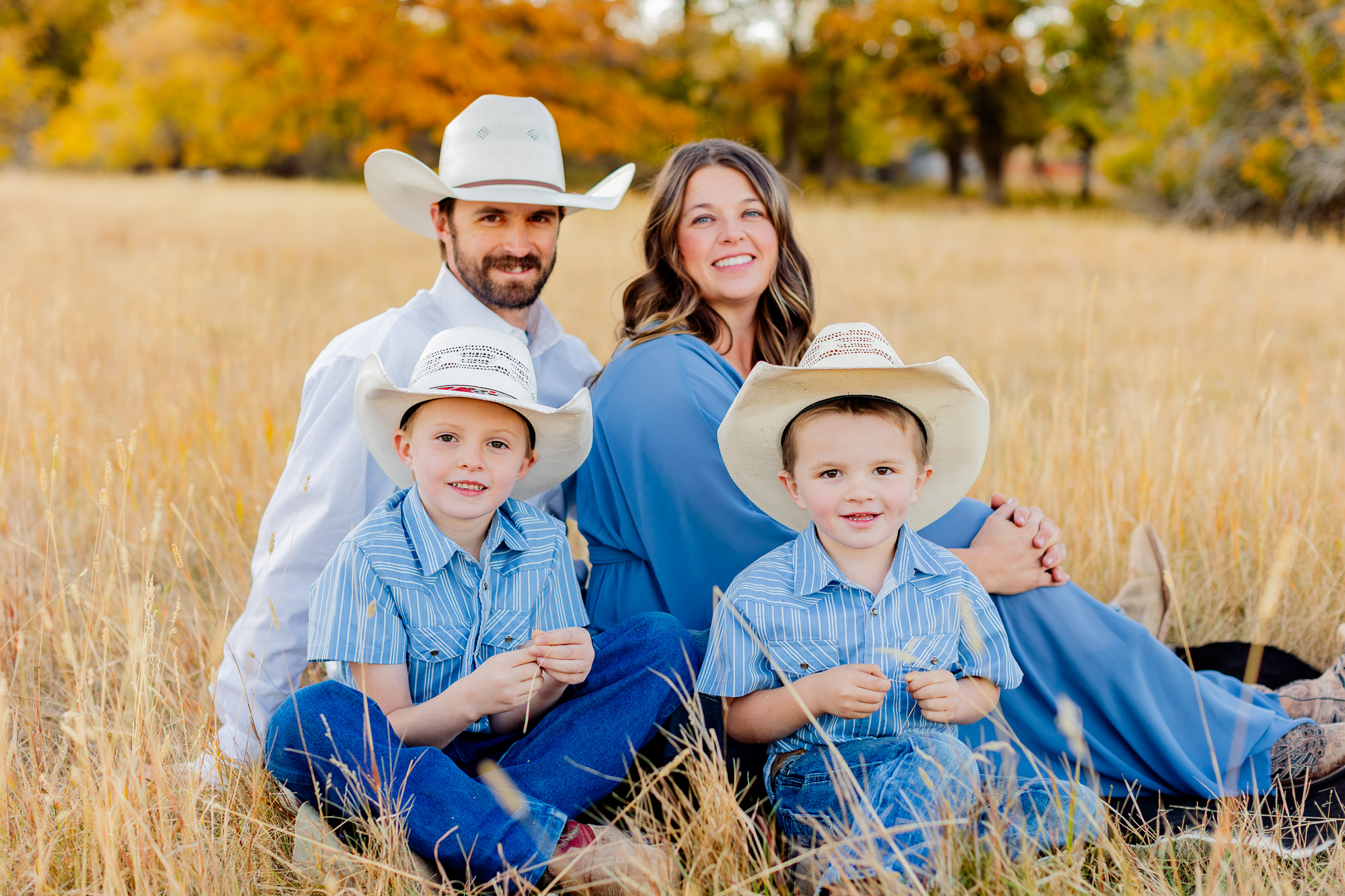 ranching family sitting in a meadow